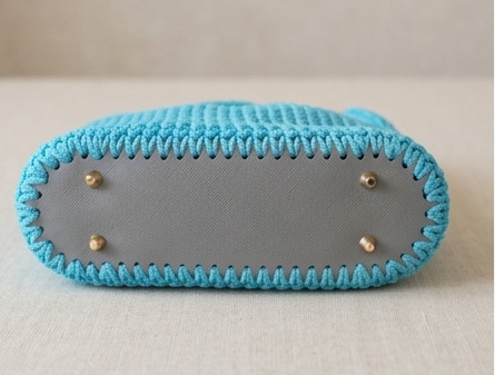 Handmade crochet handbag with structured silhouette, convertible chain handle, and gold-tone hardware.