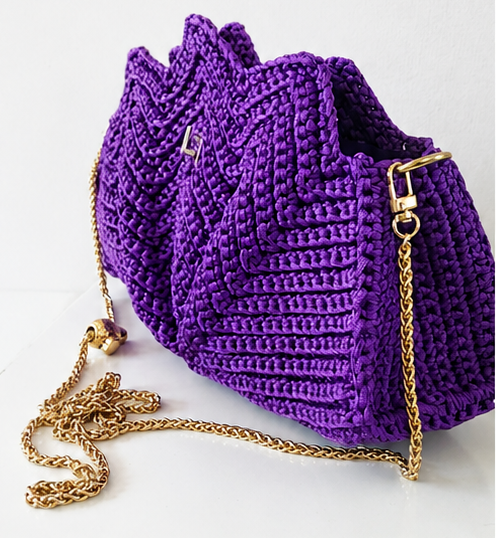 Purple woven handbag with a gold chain on a white background