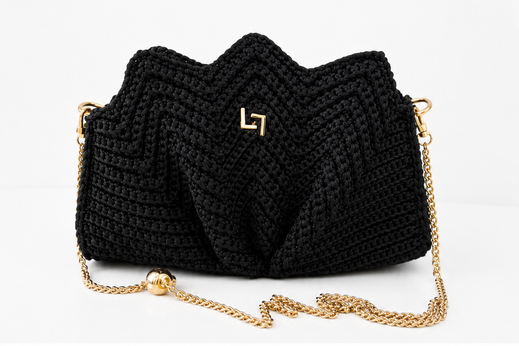 Black woven handbag with a gold chain on a white background