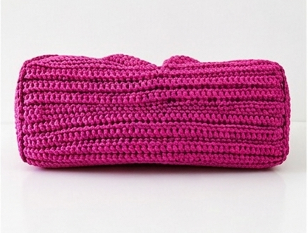 Pink knitted clutch bag on a white background